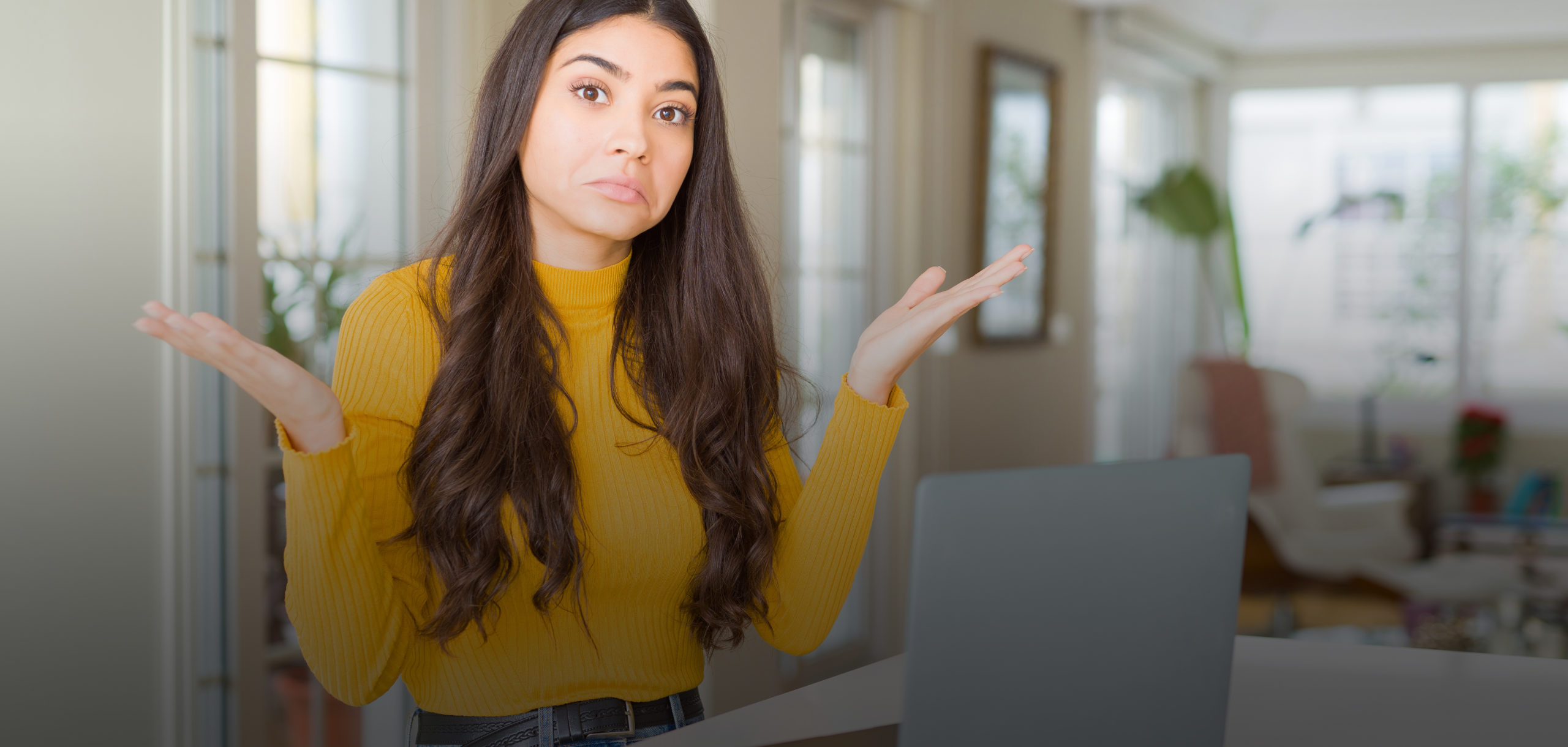 Kvinna i gul tröja är fundersam kring hur elpriserna ser ut